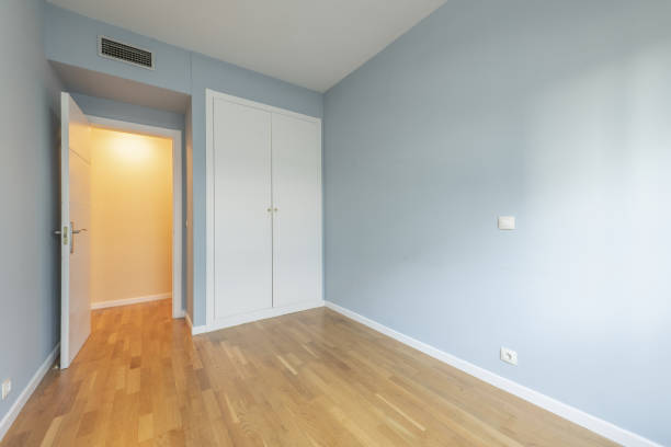Bedroom of an empty house with a white built-in wardrobe and ducted air conditioning